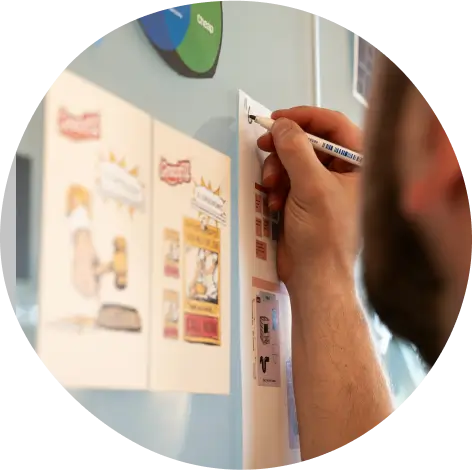 A person writing on a paper that is on the wall
